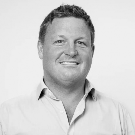 Portrait of a man in a light shirt with a gray blur obscuring his face.